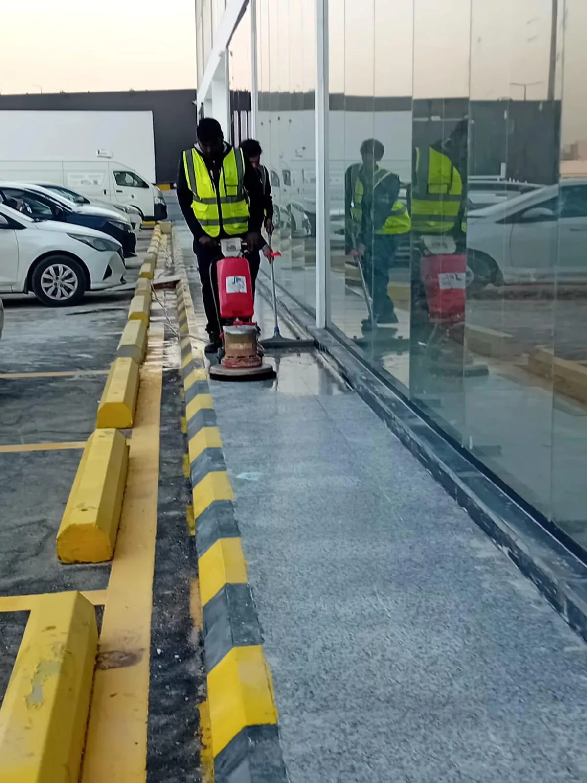 عمال ينظفون ألواح زجاج خارجية على مستوى الأرض