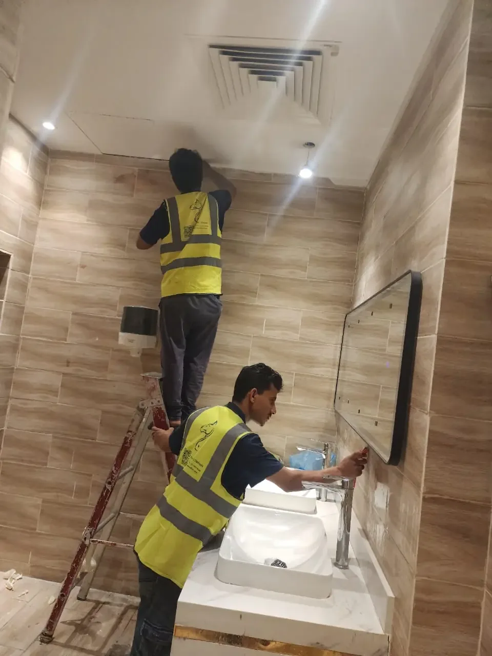 عمال ينظفون أسطح حمام تنظيفًا عميقًا