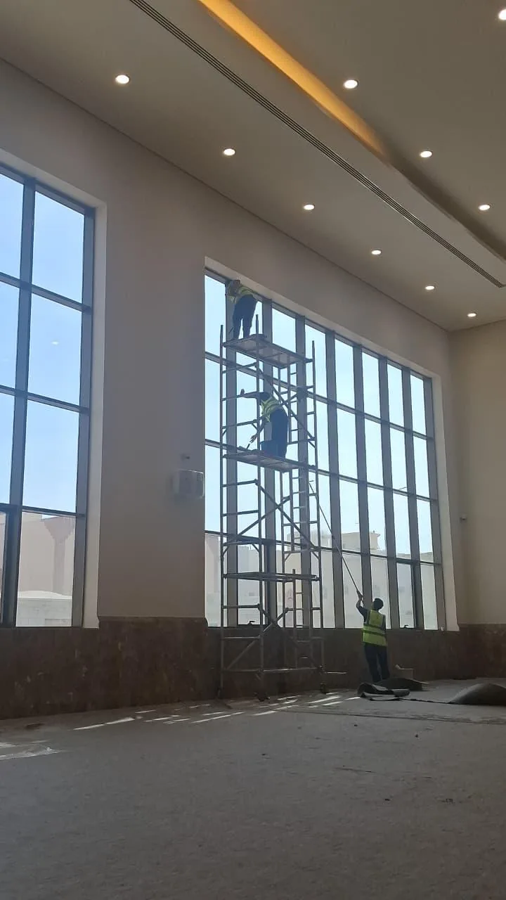 عمال ينظفون ألواح زجاج تجارية كبيرة ونوافذ