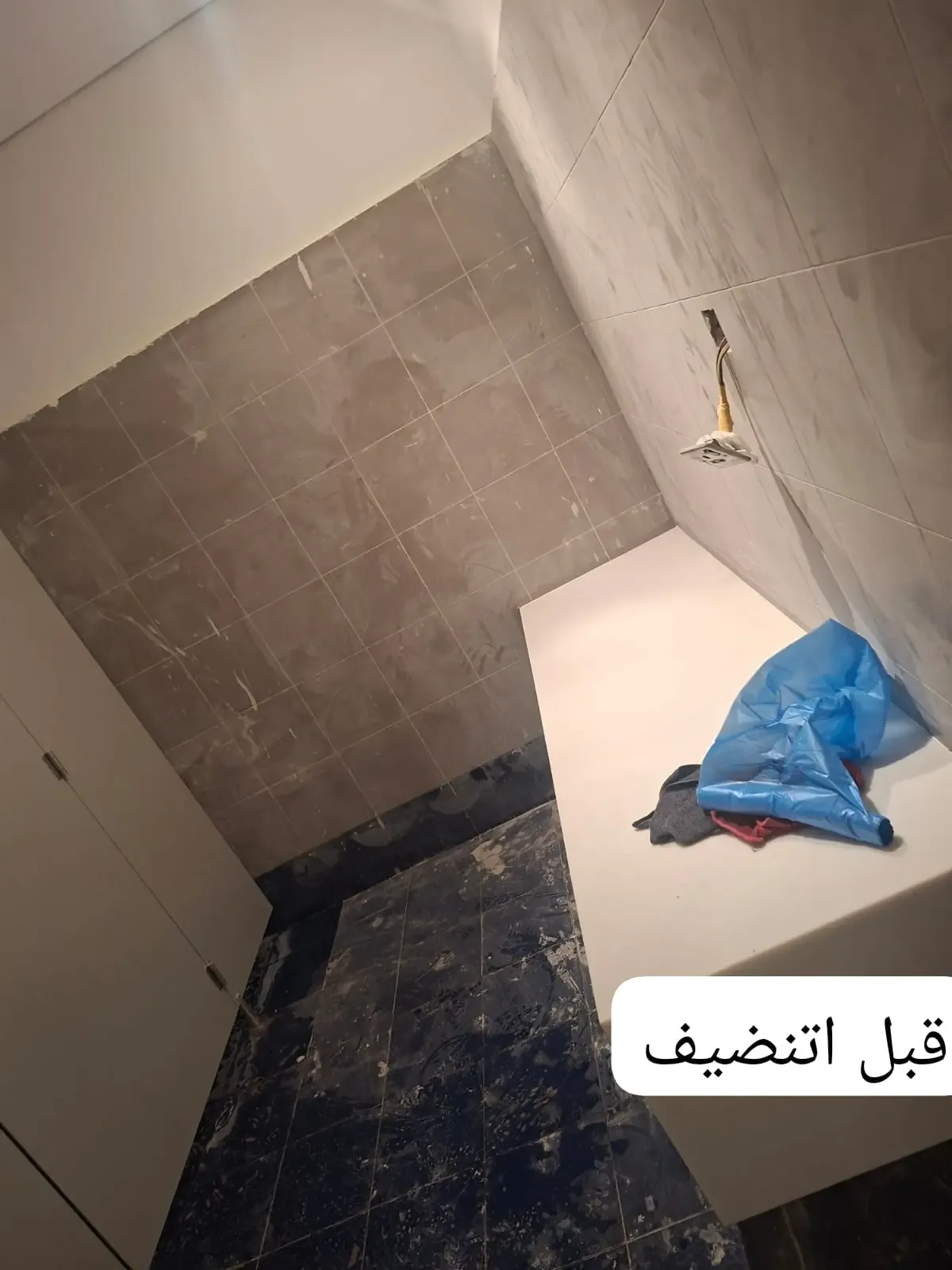 أرضية وجدران حمام عليها غشاء واتساخ قبل التنظيف