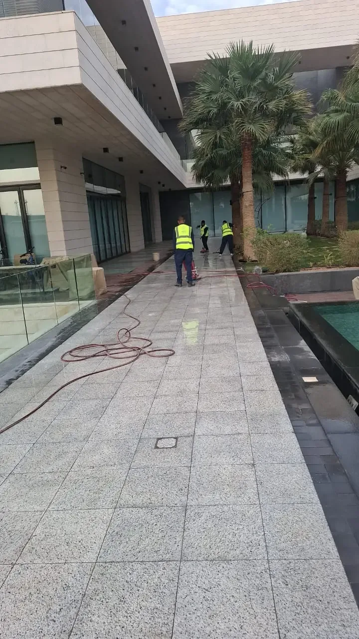 عمال ينظفون ممر حديقة فيلا
